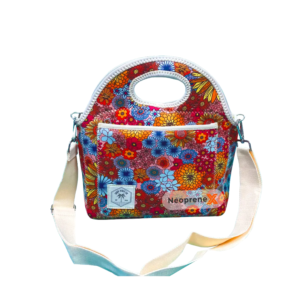 Multi-color floral patterned neoprene lunch bag with white edge binding and detachable strap.