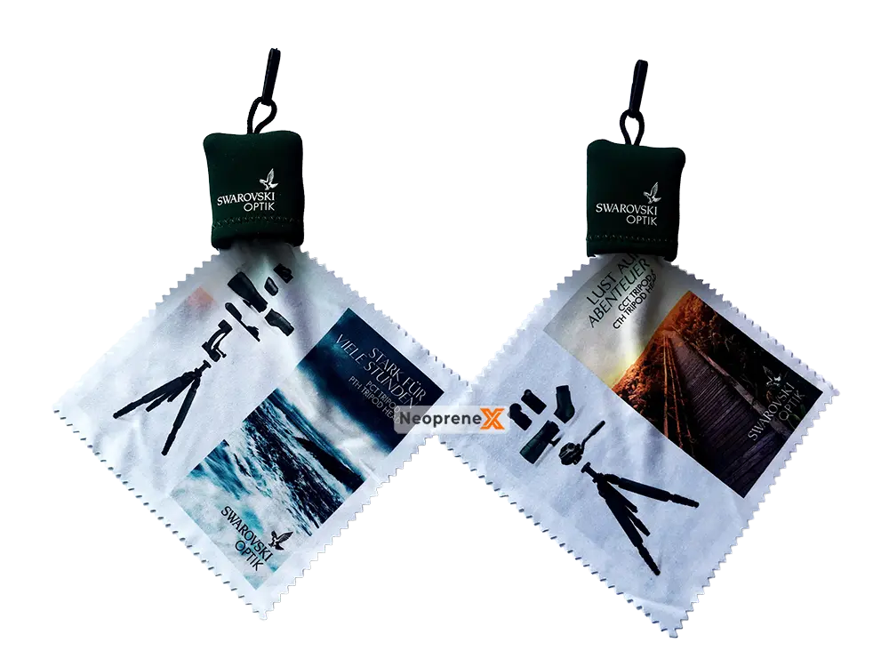 Two dark green Swarovski Optik branded neoprene pouches by NeopreneX, each featuring an integrated micro-fiber lens cleaning cloth with high-definition graphic prints.