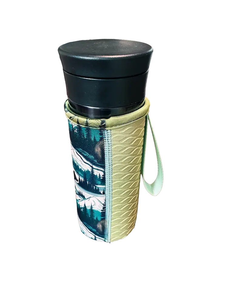 A finished custom 15.0cm neoprene bottle sleeve with a high-definition mountain wilderness pattern, showcasing 100% color fidelity and seamless integration of the webbing handle and embossed grip.