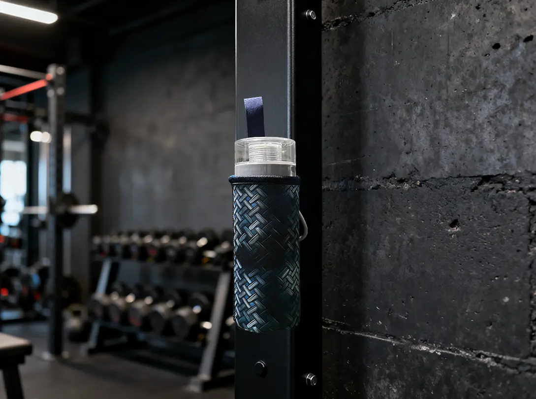 Industrial-grade N52 magnetic water bottle sleeve attached to a gym power rack, demonstrating hands-free convenience during high-intensity training.