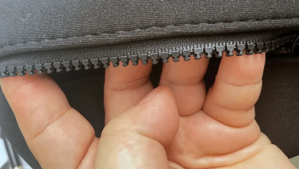 Precision zipper integration on neoprene using high-frequency voltage pre-creasing for perfectly straight stitch lines and folded edges.