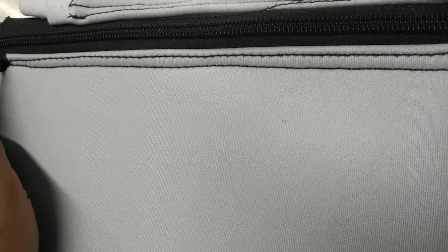 Zipper stitching on 3mm neoprene without high-frequency pre-creasing showing wavy stitch lines and material distortion.