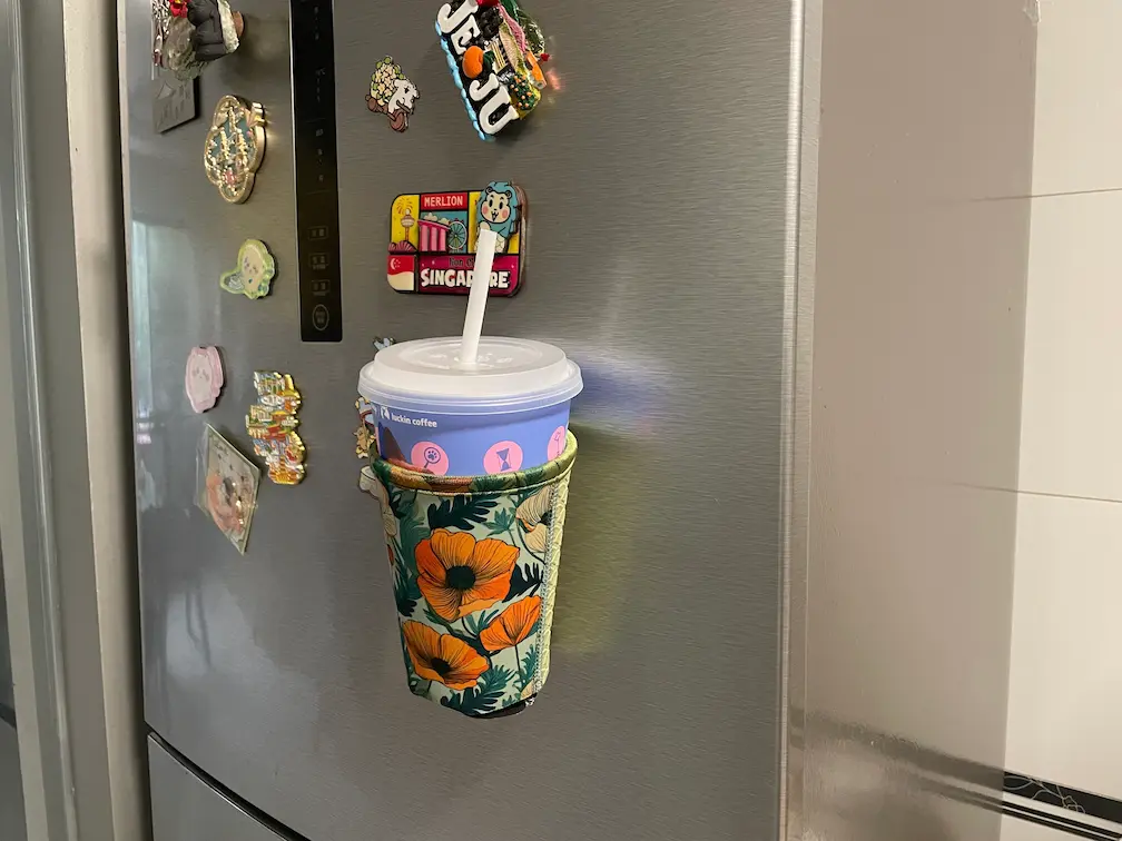 Vertical storage of a blank magnetic coffee sleeve on a steel refrigerator surface, highlighting the profit-edge for wholesale sublimation businesses.