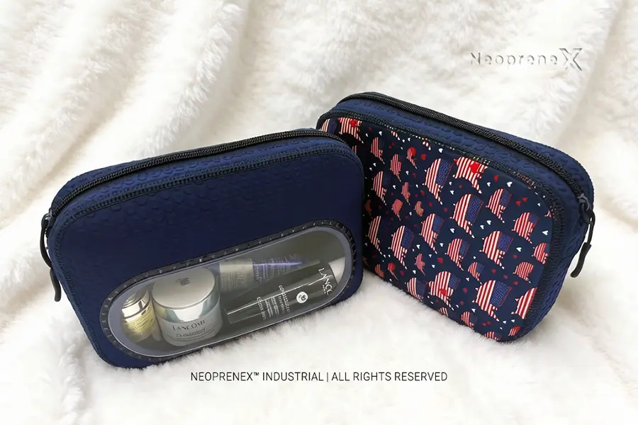 Set of navy neoprene cosmetic bags including a transparent-window TSA pouch and a solid embossed pouch styled with mini skincare items