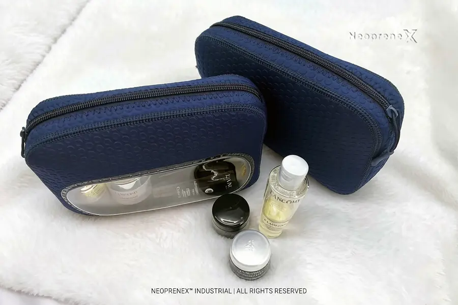TSA-friendly navy neoprene makeup bag with transparent window displaying travel-size skincare bottles for airport security