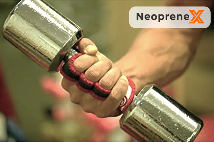 A close-up of an athlete's hands wearing NeopreneX black half-finger neoprene training gloves while firmly gripping a steel knurled barbell bar, demonstrating high-traction palm protection and adjustable wrist strap stability for heavy weightlifting use cases.