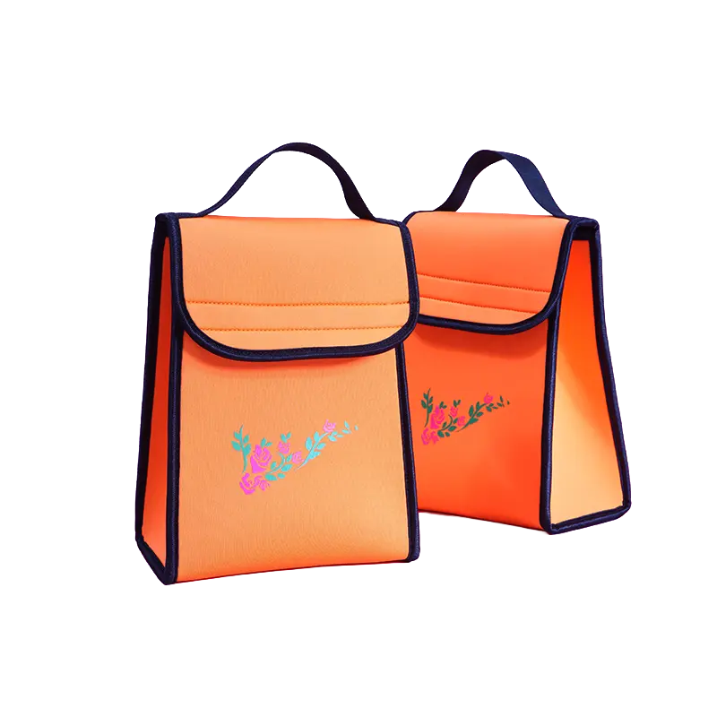 The Origami upright fold-over neoprene lunch bag in bright orange with floral prints, featuring a unique triangular side profile, structured flap closure, and durable top handle.